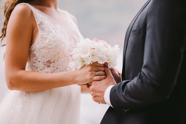 Recém-casados segurando buquê de casamento — Fotografia de Stock