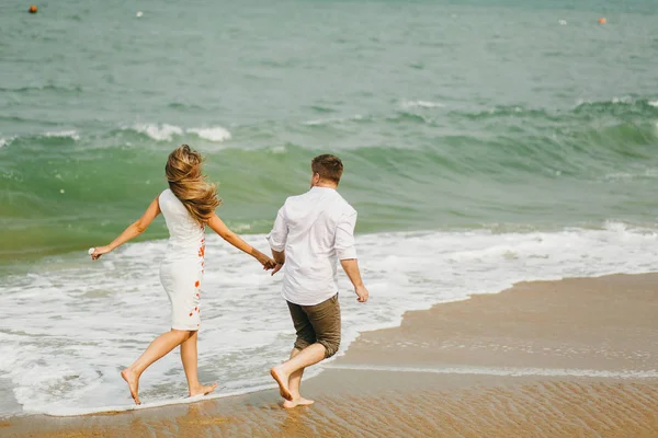 Couple heureux courir sur la plage — Photo