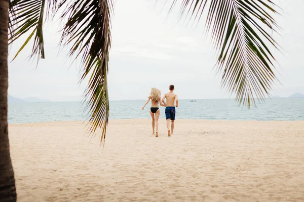 happy couple run on beach