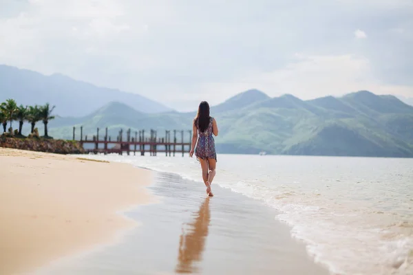 Eenzame vrouw lopen aan zandstrand — Stockfoto