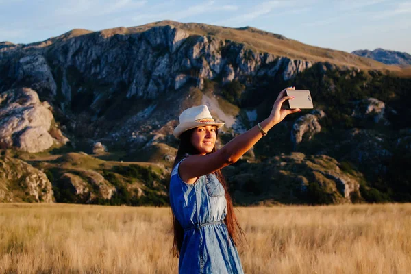 country woman making selfie photo in mountains