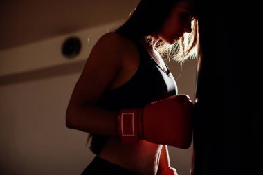 Boks torbası ile spor salonunda seksi savaşçı kız