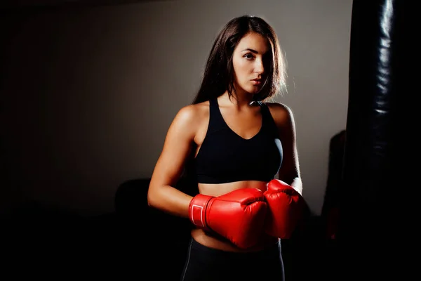 Сексуальна дівчина-винищувач в тренажерному залі з боксерською сумкою — стокове фото