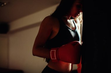 Boks torbası ile spor salonunda seksi savaşçı kız