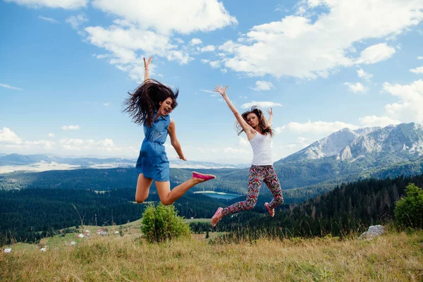 Gelukkig zijn vrouwen reizen en samen springen — Stockfoto