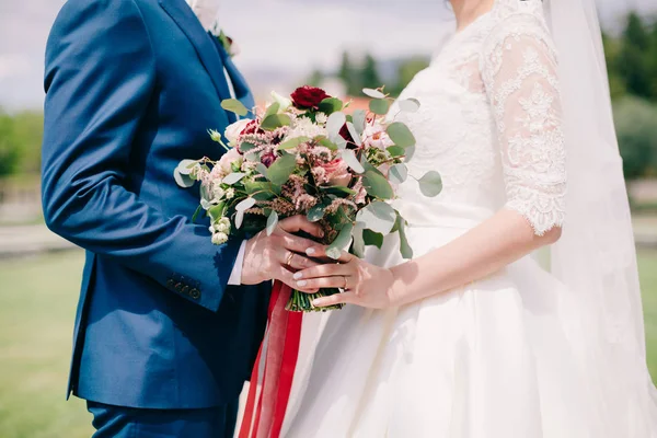 Noiva e noivo segurando buquê de casamento — Fotografia de Stock