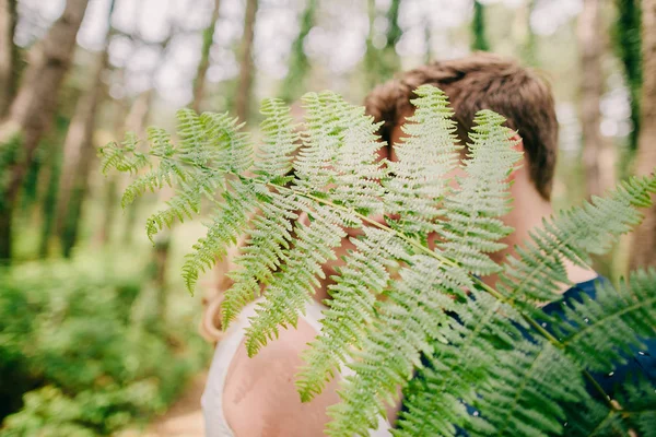 Paar küsst sich hinter Blättern — Stockfoto