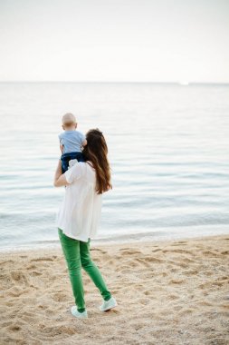 Çocuk annesiyle kumsalda dinlenmek