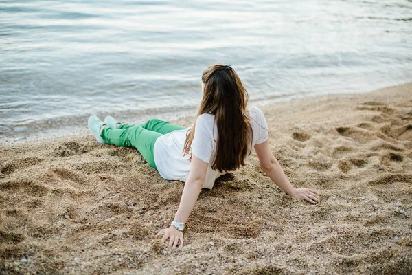 Женщина в зеленых брюках на пляже — стоковое фото