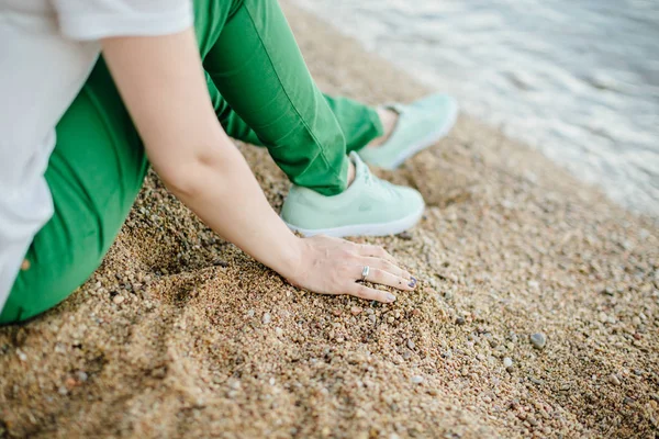 Vrouw in groene broek op strand — Stockfoto