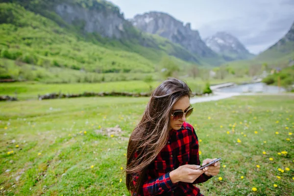 Mujer con mochilero smartphone en las montañas —  Fotos de Stock