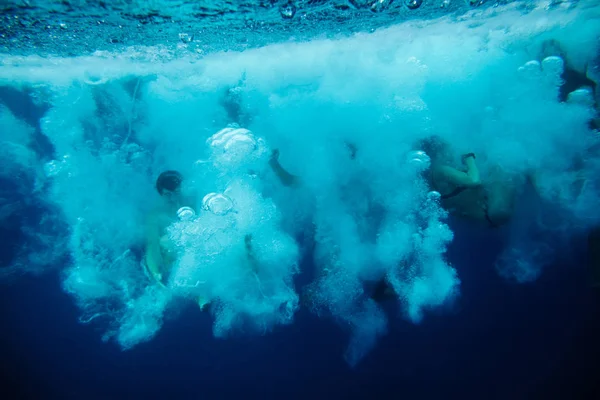 Группа людей плавает под водой — стоковое фото