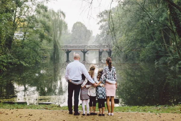 big family hug each other on lake shore with beautiful view. Family time