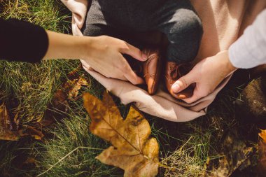 Baba ve çocuğun bacakları tutan anne kapatın. Arka plan yaprak. Üstten Görünüm