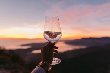 Şampanya Kadehi günbatımında tutan el