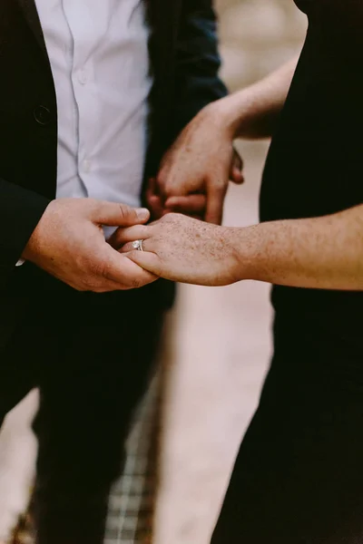 Мужчина держит женщину за руку обручальным кольцом — стоковое фото