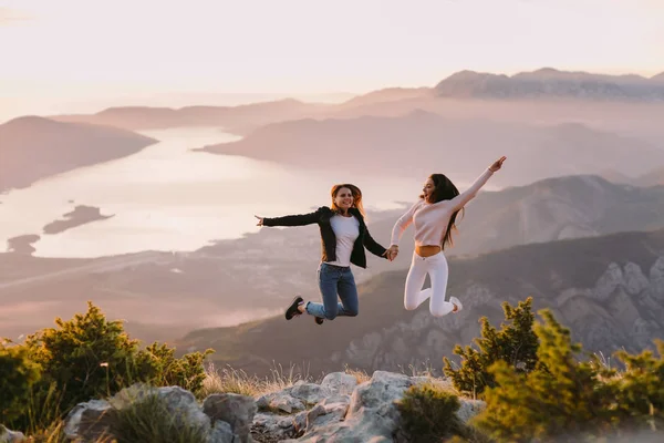 Dos Chicas Saltan Viajan Las Montañas Atardecer Con Una Hermosa —  Fotos de Stock