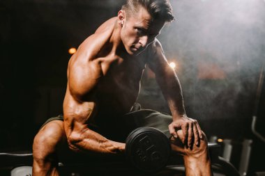 Spor salonundaki vücut geliştiren adam ellerini kaldırıyor. Spor salonundaki vücut geliştirme portresi. Konsantrasyon