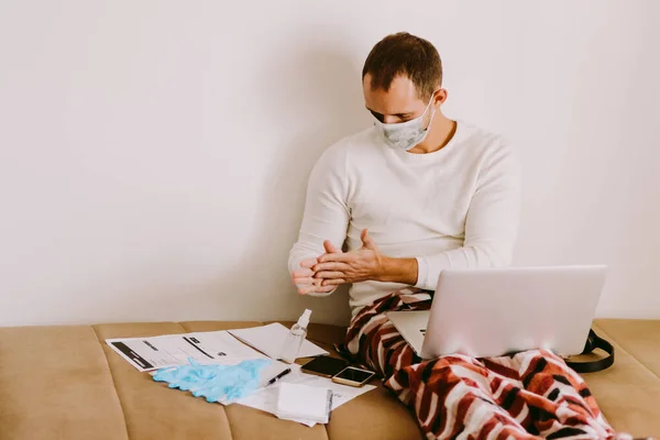 man using liquid hand sanitizer during quarantine at home. Caucasian male working at home and using alcohol gel to clean hands and skin against virus, germs, bacteria for health care. Stay at home