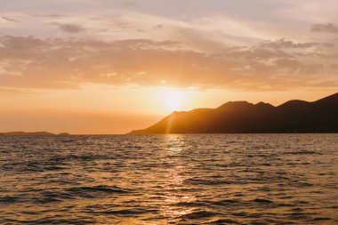 Dağlar manzaralı güzel bir deniz batımı. Resimli deniz manzarası. Romantik atmosfer