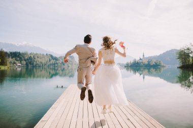 Mutlu balayı çifti Avrupai, Slovenya. Düğün çifti mutlu atlama ve seyahat Slovenya, Lake Bled.
