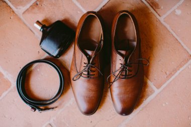 Adamın aksesuar koleksiyonu parfümle kaplıydı. Erkek ayakkabısı, kemer ve parfüm. Adamın aksesuar geçmişi.