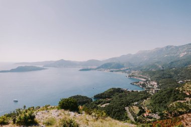 Buda 'daki dağlarla deniz manzarası. Karadağ 'da Budva Riviera manzaralı deniz manzaralı yaz manzarası.