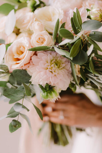 bride holding wedding bouquet in fine art style. Fine art wedding bouquet with peonies. Airy photo