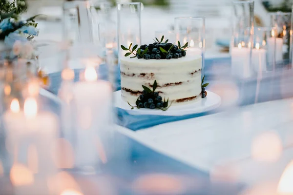 ブルーベリーとブラックベリーのウェディングケーキにろうそくが灯されます エレガントな美術結婚式の写真 — ストック写真