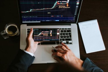 Borsa simsarı bitcoin fiyat eğilimini analiz ediyor. Yatırım komisyoncusu telefon ve dizüstü bilgisayarla Bitcoin şifreli para ticareti yapıyor. Çoklu aygıtlar.