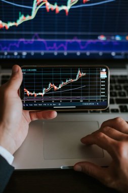 Borsacı şamdanlarla ticaret grafiğinde kar analizi yapıyor. Ofiste birden fazla aygıt kullanarak finansal hisse senedi ticareti kazancı.