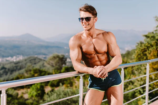 Atrakcyjny Muskularny Mężczyzna Uśmiechający Się Pozujący Kąpielówkach Świeżym Powietrzu Modelka — Zdjęcie stockowe