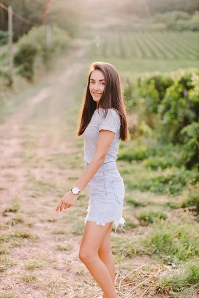 smiling woman walk at countryside summer. Relaxing at village countryside. Green vineyard background.