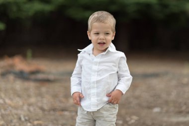 Beyaz gömlekli şirin mutlu yürümeye başlayan çocuk