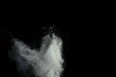 Beyaz toz patlaması siyah arkaplanda izole edildi.