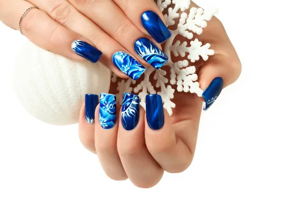 Vrouwelijke handen met Nieuwjaar ontwerp op de nagels houden sneeuwvlok. — Stockfoto