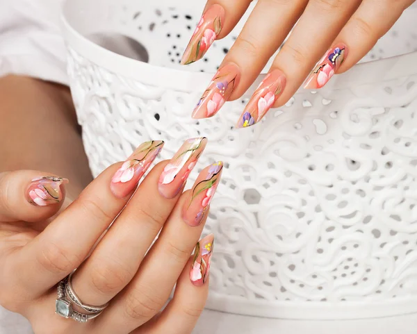 Mano de mujer con uñas de diseño de arte floral  . — Foto de Stock