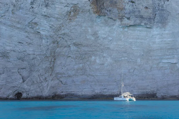 Jacht op de achtergrond van rotsen in een baai met witte rotsen — Stockfoto