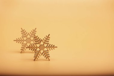 Sarı arka planda iki ahşap kar tanesi