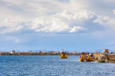 Uros adaları, Titicaca Gölü, Peru, Güney Amerika - 2019-12-01. Adanın manzarası, sazlıklardan gelen bir tekne, bulutlarda mavi gökyüzü.