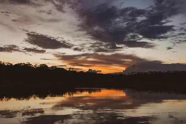 Beautiful orange sunset, sky in the clouds, above the lake and forest. — Stock Photo, Image