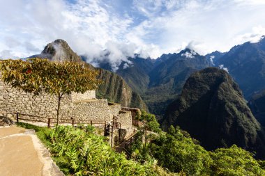 Houses and walls of the city of Machu Picchu, Peru. Clouds and mountains. UNESCO.