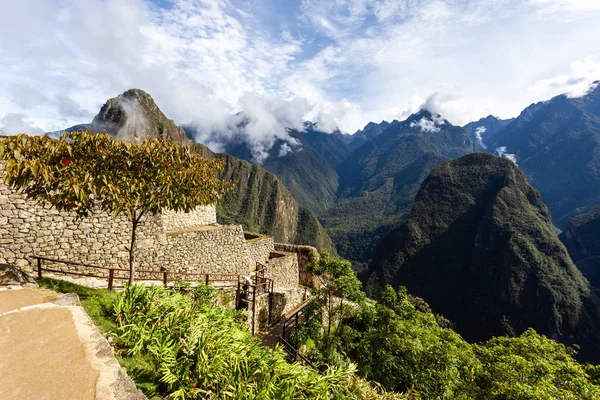 Houses and walls of the city of Machu Picchu, Peru. Clouds and mountains. UNESCO. — Stok fotoğraf
