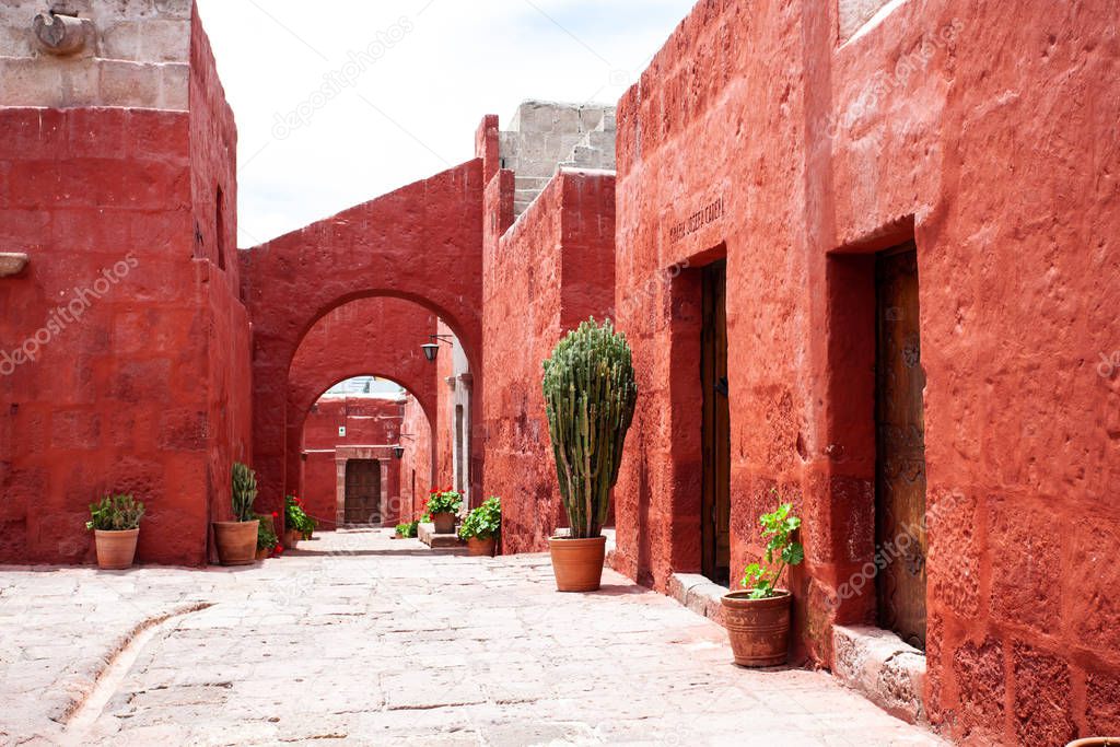 Arches in the courtyard in the monastery of Santa Catalina, Arequipa, Peru, large cacti and potted geraniums.