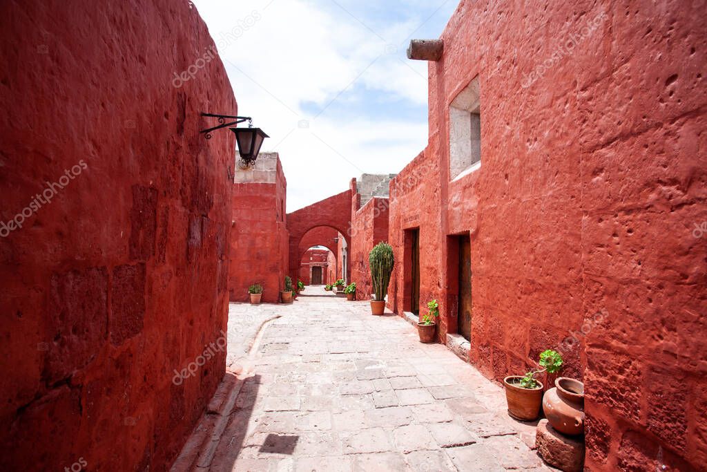 Arches on the streets in the monastery of Santa Catalina, Arequipa, Peru, large cacti and geraniums in pots.