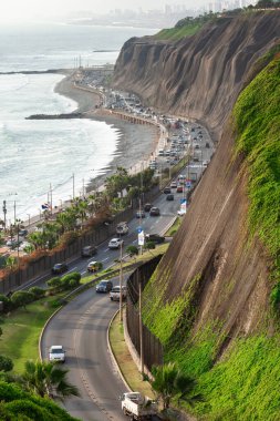 2019-12-07 Lima, Peru. Highway view, traffic, green slope, vertical orientation.