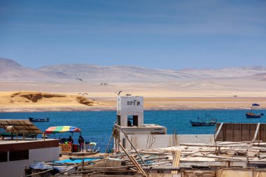 2019-12-05 Paracas Ulusal Rezervi, Peru. Körfez manzarası, binalar, çöl, tekne.