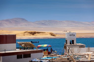 2019-12-05 Paracas Ulusal Rezervi, Peru. Körfez manzarası, binalar, çöl, tekne.