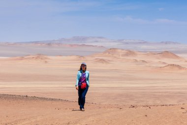 Peru, Paracas çölünde bir kadın yürüyor..