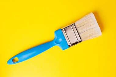 Sarı arka planda mavi kalemle fırçala, yakın plan.